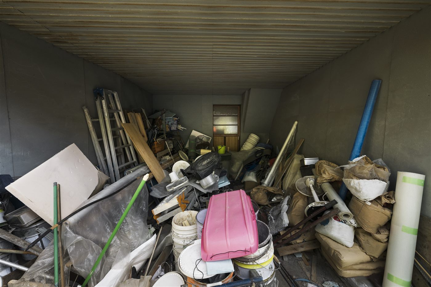 Garage packed full of rubbish and junk before clearing